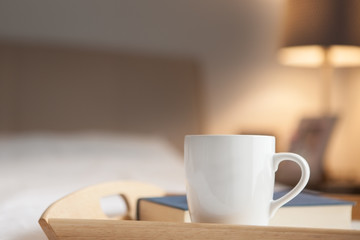 Cup of hot drink and book on bed - 297287529