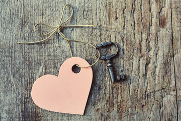 Handmade heart with antique key together lying on wooden Board. Valentine. Space for text. The view from the top