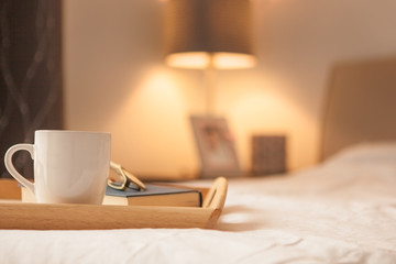 Cup of hot drink and book on bed - 297287595