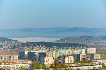 Fototapeta na wymiar Residential complex in the Northern part of Miass, Russia. In the background, the Ural mountains, Ilmen ridge and the village of Turgoyak, near lake Turgoyak