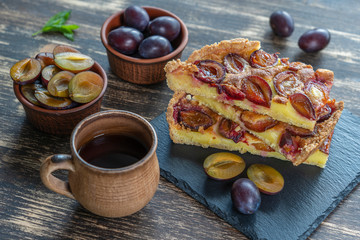 Homemade organic plum pie dessert ready to eat. Plum tart on the old wooden background, close up