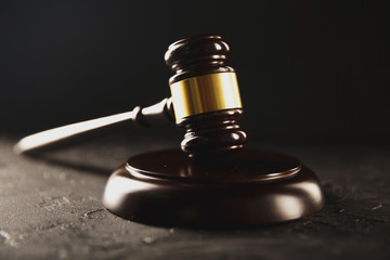 Wooden judje gavel on the dark table isolated