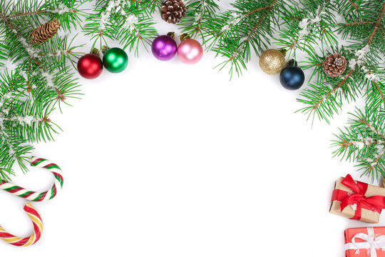 Christmas Frame of Fir tree branch with candy canes and balls isolated on white background with copy space for your text