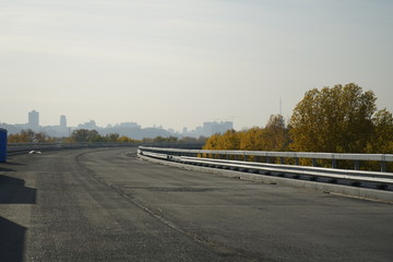 Unfinished bridge against the background of the silhouette of the city. Unfinished highway away city. Fender on the autobahn