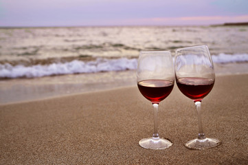 Two wine glasses on sand.