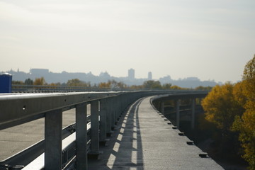 Unfinished bridge against the background of the silhouette of the city. Unfinished highway away city. Fender on the autobahn