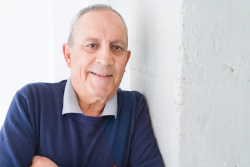 Obraz premium Handsome middle age senior man smiling cheerful, happy and positive leaning over white background with crossed arms