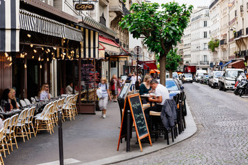 Gemütliche Straße mit Cafétischen im Viertel Montmartre in Paris, Frankreich