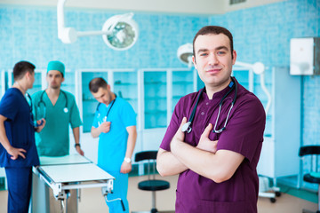 Portrait of a successful professional doctor. The staff of the medical faculty. multinational people - doctor, nurse and surgeon. A group of graduates of a medical university in a surgical room.