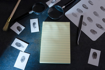 Detective`s desk and different special tools for investigation. Blank notebook, evidences,...