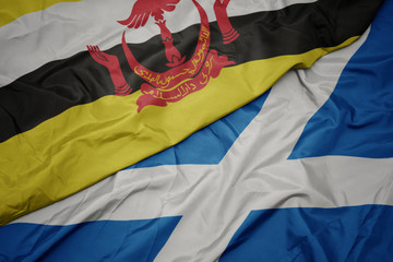 waving colorful flag of scotland and national flag of brunei.