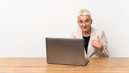 Teenager girl with short hair with a laptop with surprise facial expression