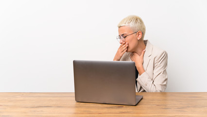 Teenager girl with short hair with a laptop is suffering with cough and feeling bad