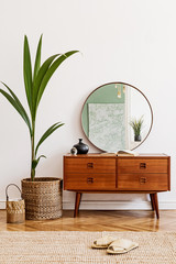 Stylish and retro composition of living room with design wooden retro commode, mirror, a lot of plants and elegant accessories. Modern home decor. Template. Mock up poster frame on the wall. 