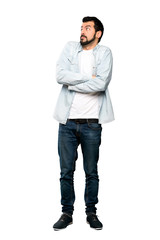 Full-length shot of Handsome man with beard making doubts gesture while lifting the shoulders over isolated white background