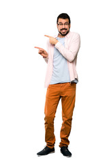 Full-length shot of Handsome man with beard frightened and pointing to the side over isolated white background