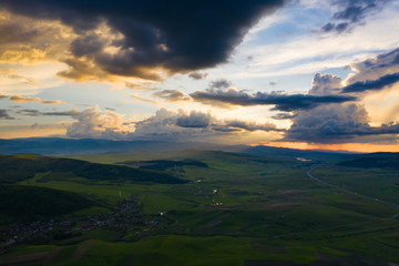 Stormy sky over green summer country landscape.