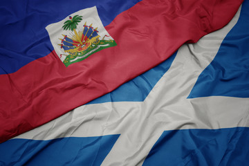 waving colorful flag of scotland and national flag of haiti.