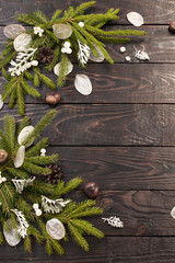 Christmas fir branches and decorations on dark wooden background