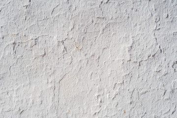 Weathered old plaster painted white, during sunny day