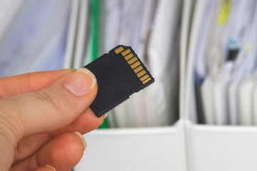 documents and hand holding flash drive, selective focus, concept of copying and saving data from paper to electronic media
