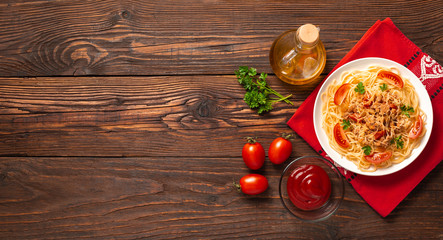 Pasta bolognese with tomato sauce and minced meat, grated parmesan cheese and fresh parsley - homemade healthy italian pasta on rustic wooden background. Flat lay. Top view.