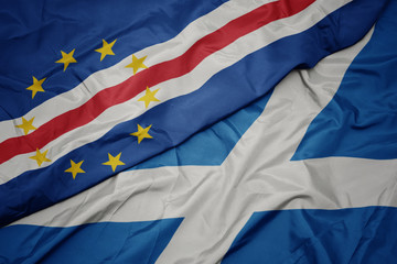 waving colorful flag of scotland and national flag of cape verde.