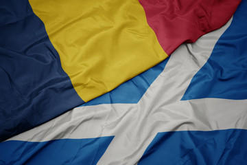 waving colorful flag of scotland and national flag of chad.