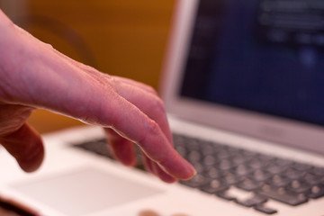 woman reaches for a laptop keyboard. Computer literacy training concept.