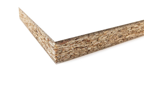 Wood chips and sawdust pressed into sheet material. On a white background with place for text. Uni color board. For the manufacture of cabinet furniture.