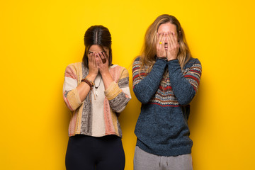 Hippie couple over yellow background with tired and sick expression