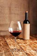Red wine in a wine glass on the background of a wine bottle