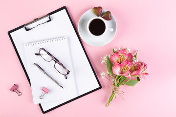 Workspace with a tablet, pen, glasses, a cup of black coffee and a bouquet of peruvian lily and...