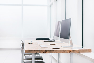 desktop with laptop and computers in an empty office.