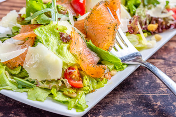 Salmon salad. Green salad with smoked salmon and parmesan cheese.