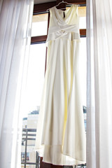 Wedding dress hanging on the window.