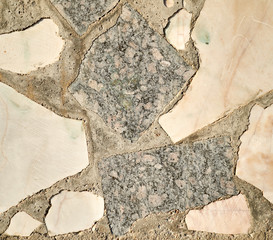Fototapeta premium Pieces of marble and granite bonded with gray cement.