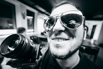 Portrait of stylish american videographer in glasses  is working on the report © andrew_shots
