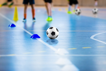 Futsal soccer training field. Young futsal players with balls on training. Close up of futsal ball. Futsal Junior Player on Indoor Training. Soccer Winter Class at School Indoor Futsal Court