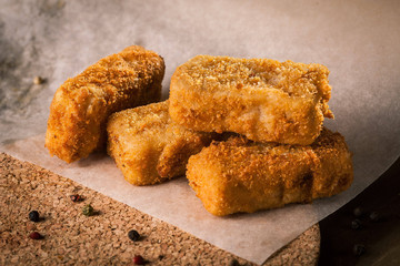 Fried fish on baking paper with peppercorns