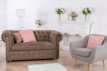 The interior of the cozy relaxation area. Gray armchair and sofa in light room