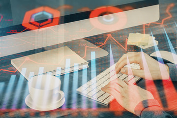 Multi exposure of graph with man typing on computer in office on background. Concept of hard work.