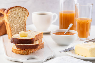 Freshly brioche bread and butter, juice and jam. Continental breakfast.