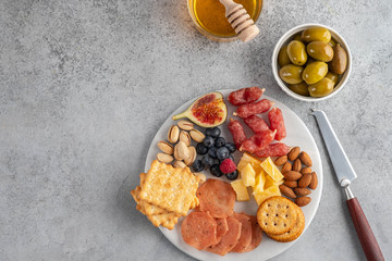 Fototapeta na wymiar Meat and cheese plate.Traditional italian antipasto, cutting board with salami, cold smoked meat, prosciutto, ham, cheeses, olives, capers on white background. Cheese and meat appetizer. Top view.