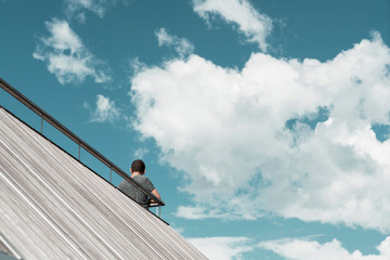 Man under the blue sky with white clouds