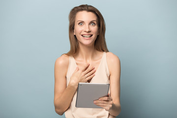 Fototapeta premium Happy Caucasian woman amazed by great news on tablet