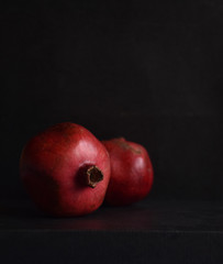 ripe red pomegranate in the skin on a black background