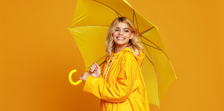 Young Happy Emotional Girl Laughing  With Umbrella   On Colored Yellow Background