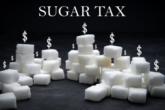 Sugar Tax Or Sugary Drink Levt Concept. Heaps Of Sugar Cubes With 