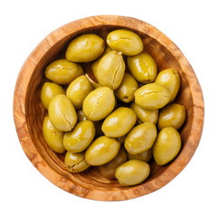 Crushed green olives in wooden bowl isolated on white background. Top view, close-up.